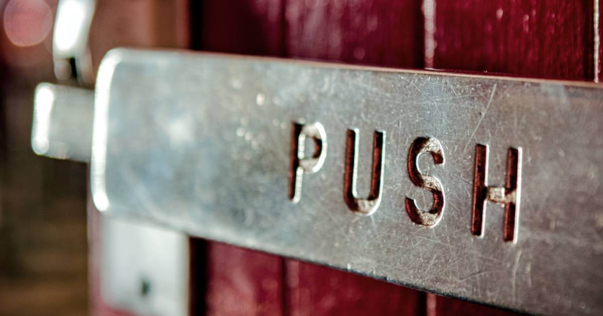 A close-up image of a push bar on a commercial door.