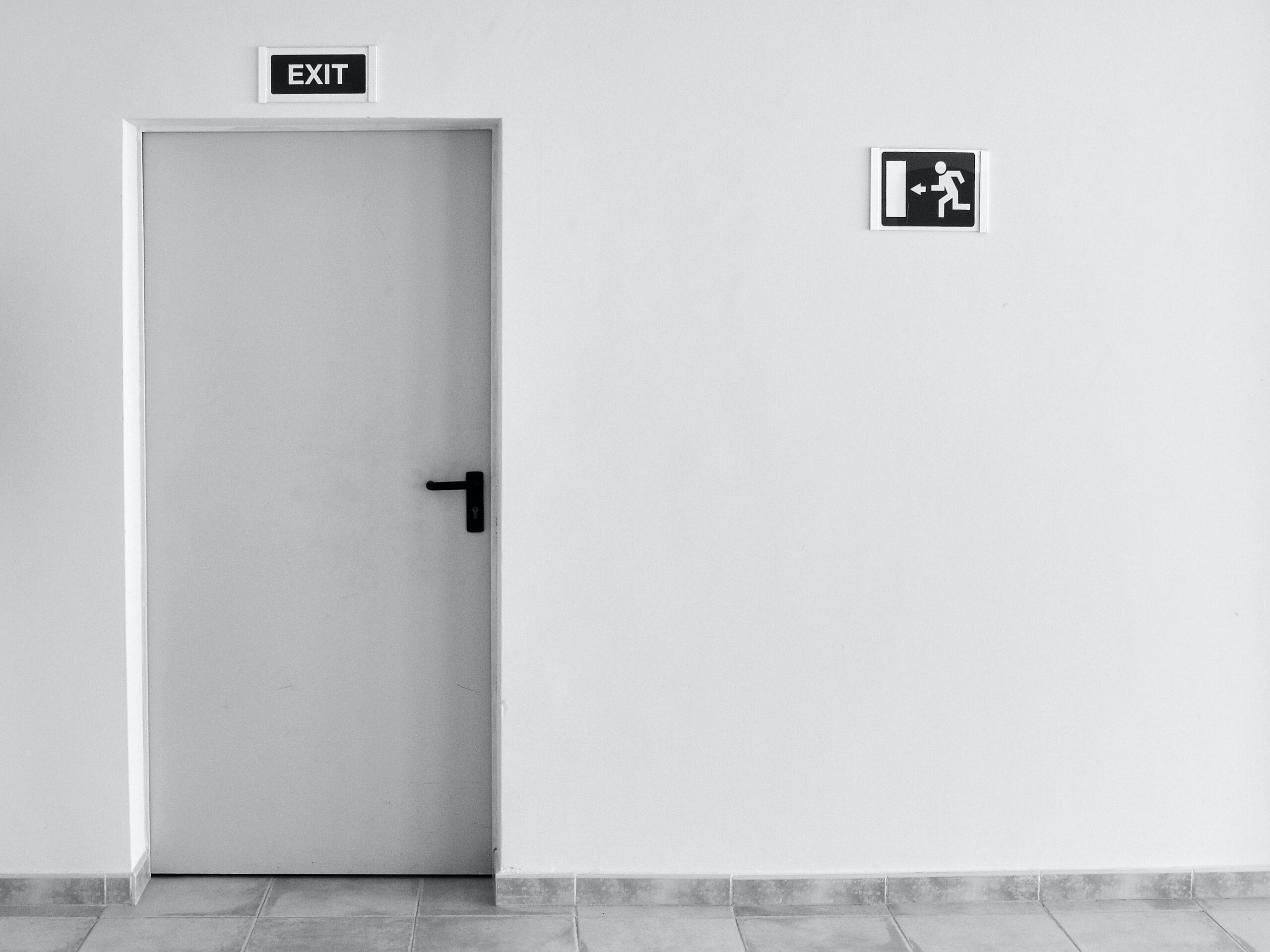An image of a white commercial door against a white wall.