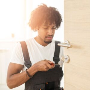 man in overalls repairing door