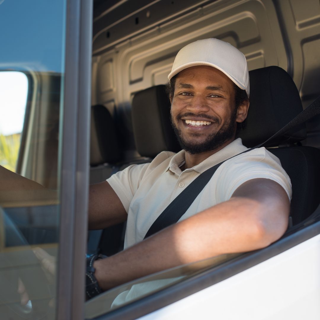 service tech driving van, smiling