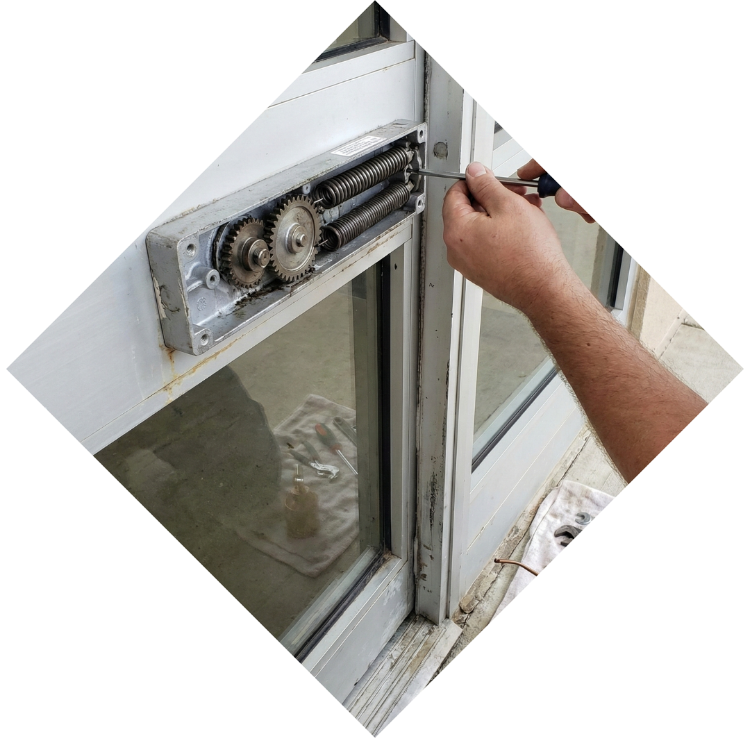 Close-up view of a commercial door closer mechanism and spring hardware being adjusted by a professional.